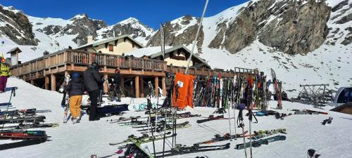 eine Skihütte mit einem Haufen Skier im Schnee in der Unterkunft Orelle Val Thorens Appartement 2 pieces 5 personnes aux portes du Parc de la Vanoise in Orelle