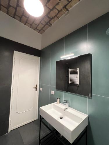 a bathroom with a white sink and a door at Miriam Apartment in Rome