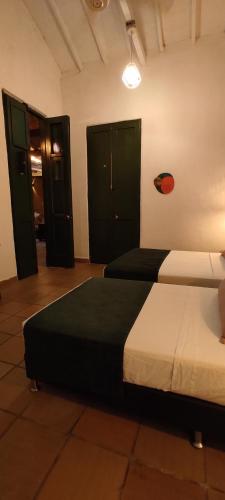 two beds in a room with two green doors at Botánica Casa Hotel in Medellín