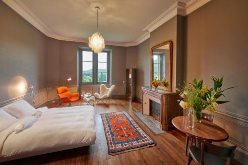 een slaapkamer met een bed, een spiegel en een tafel bij Château de Sibra in Lagarde