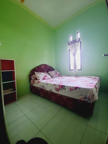 a bedroom with a bed and a window at Homestay Barokah in Magelang