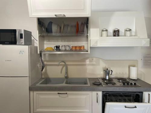 una cucina con lavandino e frigorifero bianco di Matteo House nel cuore di Sorrento a Sorrento