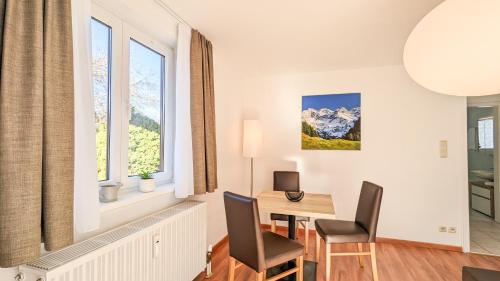 uma sala de estar com uma mesa e cadeiras e uma janela em Im Königswinkel em Schwangau