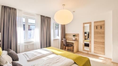 1 dormitorio con cama, escritorio y espejo en Im Königswinkel, en Schwangau