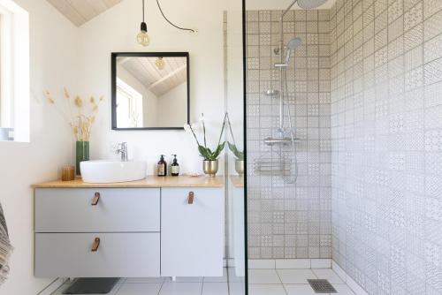 W łazience znajduje się umywalka i prysznic. w obiekcie Modern and cozy cabin near Copenhagen city and airport w mieście Dragør