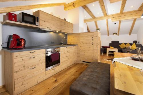 a kitchen with wooden cabinets and a living room at dahoamsei in Steeg