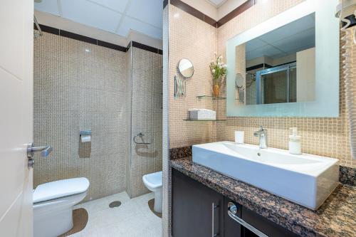 łazienka z umywalką, toaletą i lustrem w obiekcie 797 HOLIDAY RENTALS - ARCOSUR1- Moderno apartamento con terraza y vistas w mieście Benalmádena