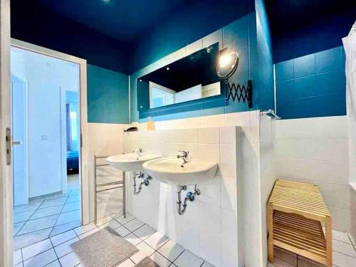 baño con 2 lavabos y techo azul en Zentrales großzügiges Apartment mit Dachterrasse!, en Bochum