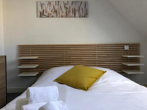 a bedroom with a white bed with a yellow pillow at Le Saint-Patern - T3 centre-ville et garage sécurisé in Vannes