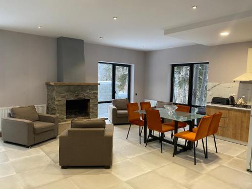 a living room with a table and chairs and a fireplace at BANOVANI Bakuriani in Bakuriani