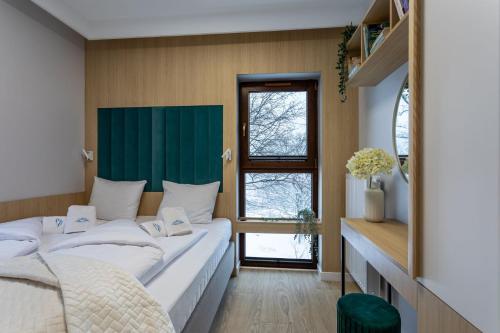 a bedroom with a large bed and a window at Green Park Resort A15- z dostępem do basenu, sauny, jacuzzi, siłowni in Szklarska Poręba