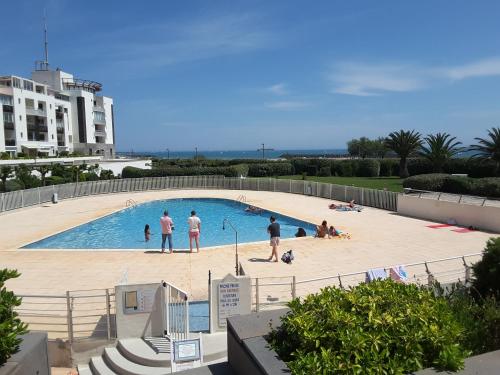 un groupe de personnes dans une piscine dans l'établissement T2 lumineux bord de mer, au Cap d'Agde