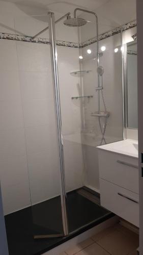 une douche avec une porte vitrée dans une salle de bain dans l'établissement T2 lumineux bord de mer, au Cap d'Agde