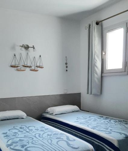 une chambre avec deux lits et une fenêtre dans l'établissement T2 lumineux bord de mer, au Cap d'Agde