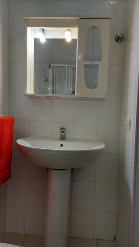 a bathroom with a white sink and a mirror at MINI HOUSE in Montescaglioso