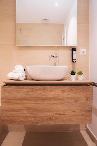 a bathroom with a white sink on a wooden counter at Hamilius Apartments City Center Luxembourg by Rentaroo in Luxembourg