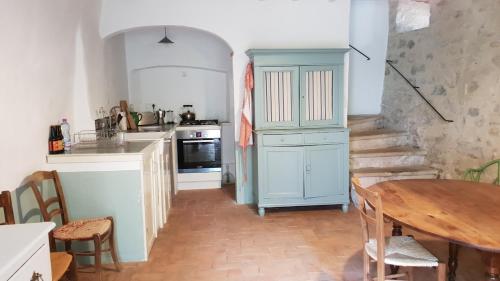 cocina con mesa y armario azul en La Cour du Marronnier, en Pont-de-Barret