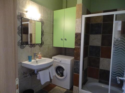 ein Badezimmer mit einer Waschmaschine und einem Waschbecken in der Unterkunft Naiad Studio in Póros