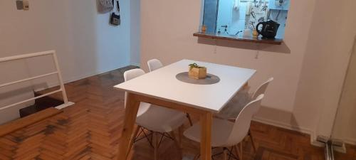 una mesa blanca con sillas y un pastel. en Departamento tipo duplex 2 ambientes Belgrano en Buenos Aires
