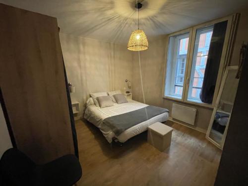a bedroom with a bed and a large window at Le Charmant Paillot Hyper Centre classé in Troyes