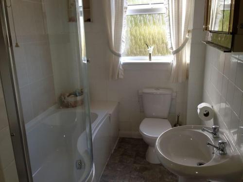 W łazience znajduje się toaleta, umywalka i prysznic. w obiekcie Dunmara: Self Catering Cottage on the Isle of Skye w mieście Broadford