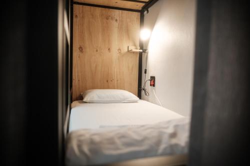 a bed in a room with a wooden wall at Villa Viva Cape Town in Cape Town