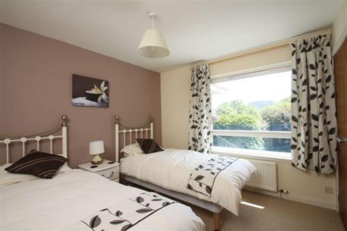 2 łóżka w sypialni z oknem w obiekcie Dunmara: Self Catering Cottage on the Isle of Skye w mieście Broadford