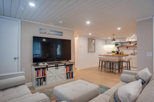 uma sala de estar com um sofá, uma televisão e uma mesa em Renovated Cottage: 4th row from the Beach! em Hilton Head Island