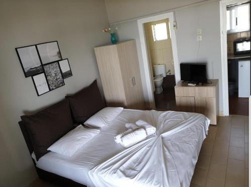 a white bed with two towels on it in a room at On the wave studios Spitakia sto kyma in Nikiti