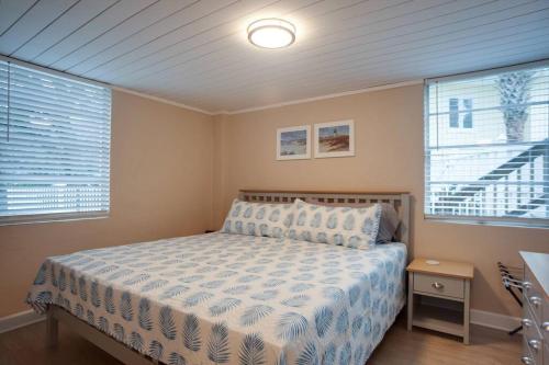 a bedroom with a bed and two windows at Renovated Cottage: 4th row from the Beach! in Hilton Head Island