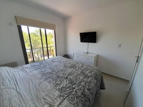 1 dormitorio con 1 cama, TV y ventana en Hermoso y luminoso departamento en Godoy Cruz en Godoy Cruz