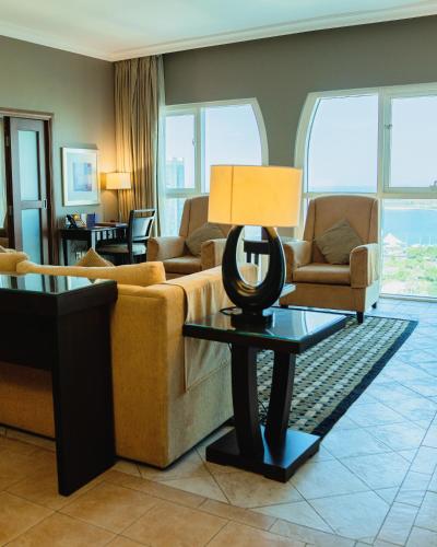 a living room with a couch and a lamp on a table at Sheraton Khalidiya Hotel in Abu Dhabi