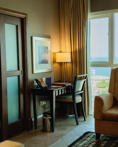 a hotel room with a desk and a chair at Sheraton Khalidiya Hotel in Abu Dhabi