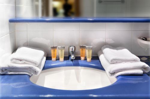 a bathroom with a tub with towels and glasses of beer at SOWELL Family Port Grimaud in Grimaud
