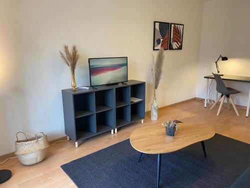a living room with a tv and a table at Comfort 1 and 2BDR Apartment close to Zurich Airport in Zürich
