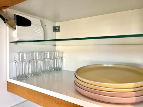 a kitchen with plates and glasses on a shelf at Apartament Aviator in Mielec