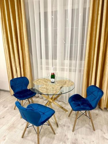 a glass table with four chairs and a bottle of wine at Luxury apartment in Bratislava in Trnávka