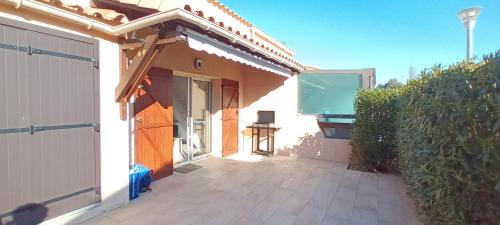 a house with a gate and a patio at CORALINES - Villa en residence in Saint-Cyprien