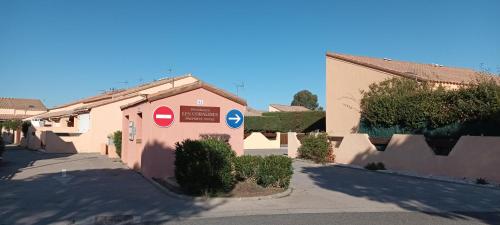 a small pink building with signs on the side of it at CORALINES - Villa en residence in Saint-Cyprien