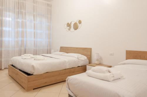 um quarto com 2 camas e lençóis brancos em BnButler - Pellegrino Rossi, 42 - Ampio e Comodo per 5 em Milão