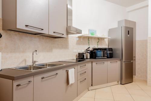 uma cozinha com um lavatório e um frigorífico em BnButler - Pellegrino Rossi, 42 - Ampio e Comodo per 5 em Milão