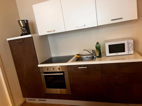 a kitchen with a sink and a microwave at Savenella Apartments in Bologna