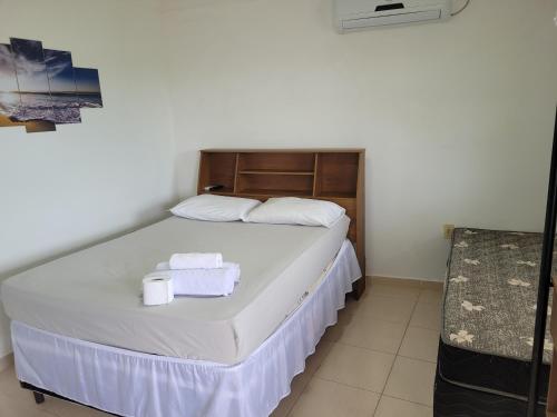 a bedroom with a bed with two towels on it at Enseada Suítes in Guarapari