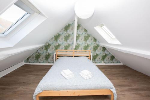 a bedroom with a bed in the attic at Villa du Bourg Disneyland & Shopping in Montévrain
