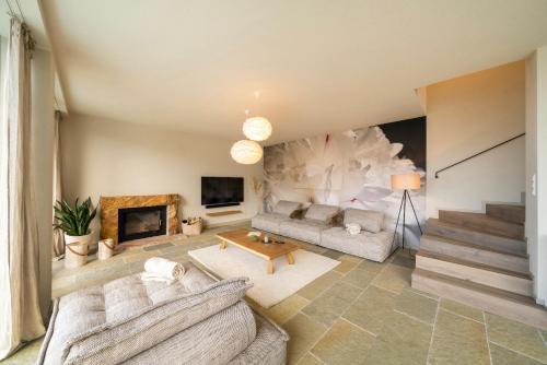 a living room with two couches and a fireplace at Thomizil Eichberg Südsteiermark in Sankt Johann im Saggautal