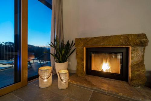 a fireplace in a living room with a view of a patio at Thomizil Eichberg Südsteiermark in Sankt Johann im Saggautal