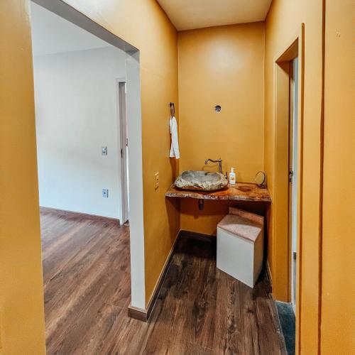a bathroom with a sink and a wooden floor at Casa Recanto da Neblina in Petrópolis
