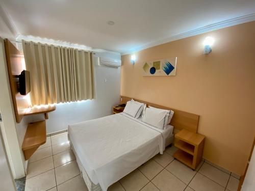 a hotel room with a bed and a television at DiRoma Fiori com um dia no Acqua park, Splash e Slide in Caldas Novas