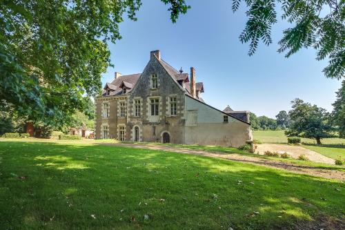 une vieille maison sur un champ herbeux dans l'établissement Magnifique château au bord de la Mayenne 18 couchages, 