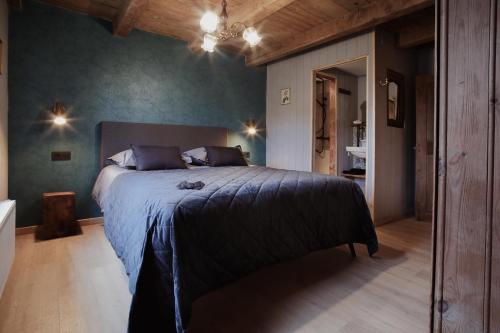 a bedroom with a large bed with blue walls at La Maison du Marcel in Sainte-Cécile